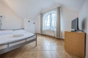 Schlafzimmer mit einem Bett und einem Flachbild-TV in der Unterkunft Pensjonat Kwiatkowski apartament nr 2 in Nowęcin