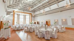 蒂珀雷里的住宿－Great National Ballykisteen Golf Hotel，宴会厅配有白色的桌子和白色的椅子