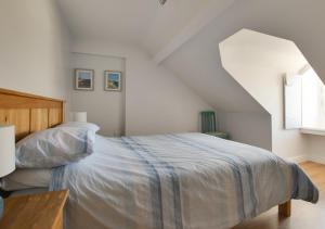 um quarto branco com uma cama e uma escada em Sea Breeze Weymouth em Weymouth