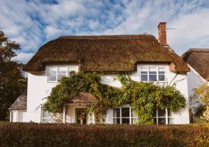 a white house with a thatched roof at Artists Coastal Retreat in Wool