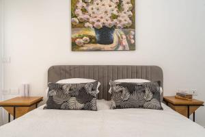 duas almofadas numa cama com um quadro na parede em Deluxe 1 Bedrooms Apartment Terrace in City Center em Jerusalém
