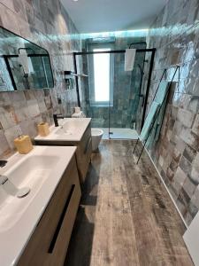 a bathroom with two sinks and a shower at Apartamenticos El Tubo I in Zaragoza