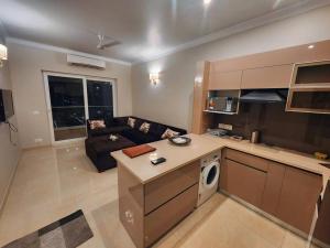 a kitchen and living room with a couch and a living room at New 1BHK at Central Park, Sohna Road, Ayaansh Resort in Gurgaon