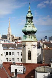una torre de reloj en la parte superior de un edificio en Hotel Zur Wiener Staatsoper, en Viena