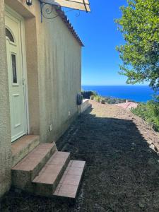 una casa con escaleras que conducen a una puerta en Maison de vacances vue mer en Calcatoggio