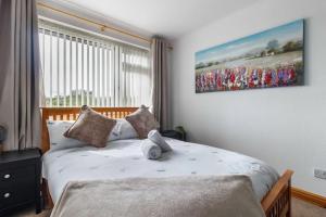 a bedroom with a bed with a picture on the wall at Modest 3 Bed Home, Normanton in Normanton