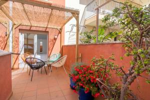a patio with chairs and a table and flowers at Citadel Oliva 4p Roses, Beach & Centre, Private Parking, Terrace in Roses