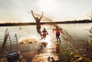 three people jumping into the water on a lake at Residences Central Winterberg in Winterberg