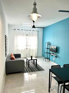 a living room with a couch and a blue wall at SEAVIEW HOLIDAY APARTMENT 6-Free WiFi & Netflix in Kuala Terengganu