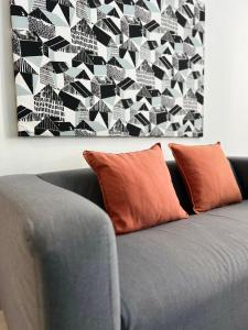 a couch with two orange pillows in a living room at SEAVIEW HOLIDAY APARTMENT 6-Free WiFi & Netflix in Kuala Terengganu