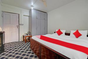 um quarto com uma cama grande e almofadas vermelhas em Flagship Comfort By Comfay em Srinagar
