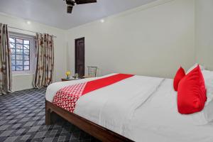 a bedroom with a large bed with red pillows at Flagship Comfort By Comfay in Srinagar