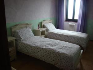 two beds in a room with purple and green at Casale Beatrice degli Olivi in Orvieto