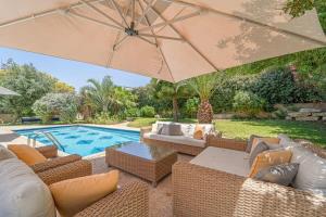 - une terrasse meublée avec un parasol à côté de la piscine dans l'établissement Luxury Villa 5 BDR Pool In Caesarea, à Césarée