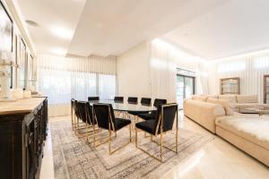 - une salle à manger avec une table, des chaises et un canapé dans l'établissement Luxury Villa 5 BDR Pool In Caesarea, à Césarée