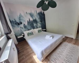a bedroom with a bed with a painting on the wall at Askade Residence Self Check-in in Bucharest