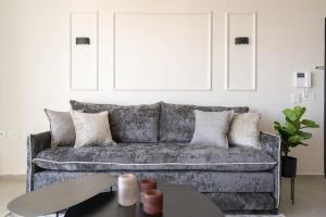 un soggiorno con un divano grigio e un tavolo di Savyon View Tower - Isrentals a Gerusalemme