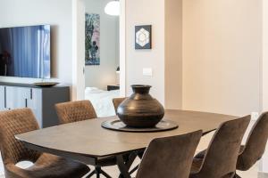 Un comedor con una mesa y sillas con un jarrón encima. en Dreamy 2 Bedroom In Best Location Parking, en Jerusalén