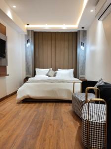 - une chambre avec un grand lit blanc et une télévision dans l'établissement Western Blu INN, à New Delhi