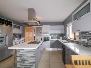 una cocina con armarios blancos y una gran encimera blanca en House on Ring Fort Hill en Ballyhoorisky