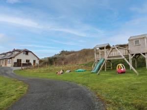 un parque infantil con tobogán y columpio en House on Ring Fort Hill en Ballyhoorisky