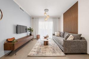 ein Wohnzimmer mit einem Sofa und einem TV in der Unterkunft Luxurious 1BDR Terrace Parking in City Central in Jerusalem