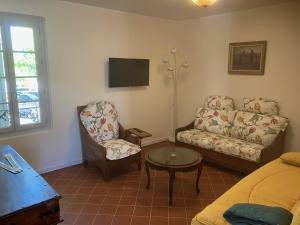 - un salon avec un canapé et une chaise dans l'établissement La Glycine, à Pézenas