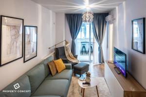 ein Wohnzimmer mit einem Sofa und einem TV in der Unterkunft Central Residence Apartment 711 in Vatra Mînăstirii Cotroceni