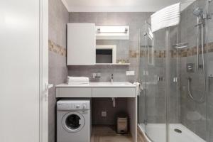 bagno con lavandino e lavatrice di Somnia Apartments a Vilnius