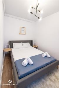 une chambre avec un lit avec deux serviettes dessus dans l'établissement Central Residence Apartment 711 B2, à Vatra Mînăstirii Cotroceni