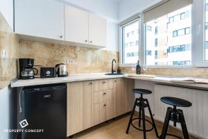 une cuisine avec un lave-vaisselle noir et deux tabourets de bar dans l'établissement Central Residence Apartment 711 B2, à Vatra Mînăstirii Cotroceni 31 autres photos