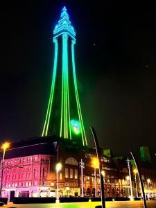 un gran edificio con una torre iluminada por la noche en The oxford Hotel, en Blackpool