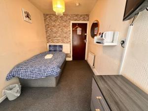 um pequeno quarto com uma cama e um micro-ondas em The oxford Hotel em Blackpool