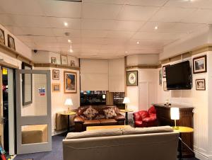 uma sala de estar com um sofá e uma televisão em The oxford Hotel em Blackpool
