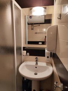 a small bathroom with a sink and a mirror at Nev in Burgas City