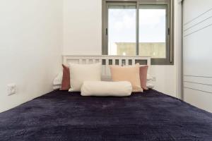 1 dormitorio con cama con almohadas y ventana en Luxury 3 Bedrooms apartment in Baka, en Jerusalén