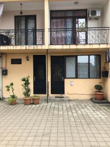 a building with two doors and potted plants in front of it at Cottage Gio in Kobuleti