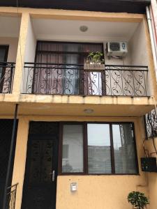 a building with a balcony with a door and a window at Cottage Gio in Kobuleti +12 photos