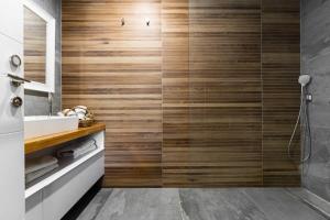y baño con ducha y paredes de madera. en Luxury 3 Bedrooms apartment in Baka, en Jerusalén