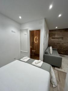 Habitación blanca con cama y sofá en Lar do Arco 1, en Pontevedra