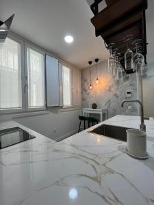 una cocina con encimeras de mármol blanco y fregadero en Lar do Arco 1, en Pontevedra