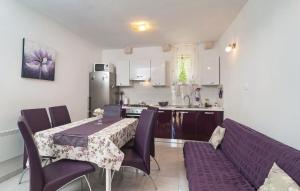 a kitchen and dining room with a table and purple chairs at Holiday Home Marijeta in Škrip