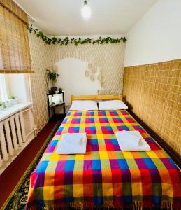 ein Schlafzimmer mit einem farbenfrohen Bett mit Handtüchern darauf in der Unterkunft Dadow Cozy House in Naryn