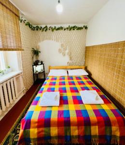 a bedroom with a colorful bed with towels on it at Dadow Cozy House in Naryn