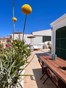 un patio con una mesa de madera y algunas plantas en GM House Minorca, en Cala'n Bosch