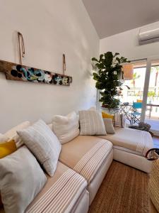 een woonkamer met een bank en een plant bij Casa Artrutx by GMHouse Minorca in Cala'n Bosch