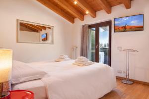 a bedroom with a large white bed and a window at Apartment Ponte Tesina in Castion Veronese +12 photos