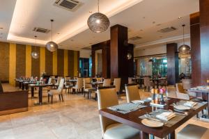 a dining room with tables and chairs in a restaurant at Crowne Plaza Nairobi Airport by IHG in Nairobi +37 photos