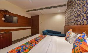 ein Hotelzimmer mit einem Bett und einem TV in der Unterkunft FabHotel The Wind Palace in Jaipur