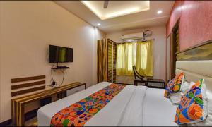 um quarto de hotel com uma cama e uma televisão em FabHotel The Wind Palace em Jaipur